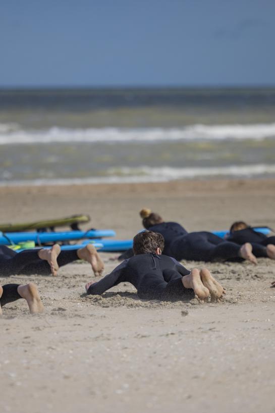 Surfers leren op het strand